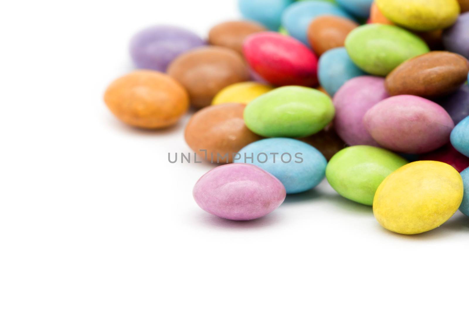 sweet dragees of different color on white background