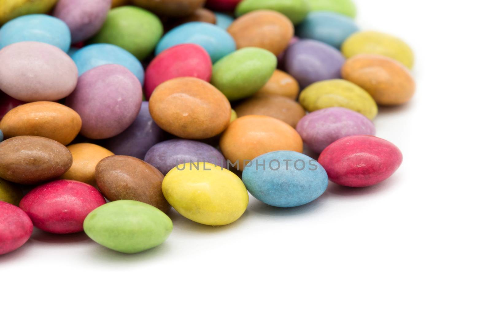 sweet dragees of different color on white background