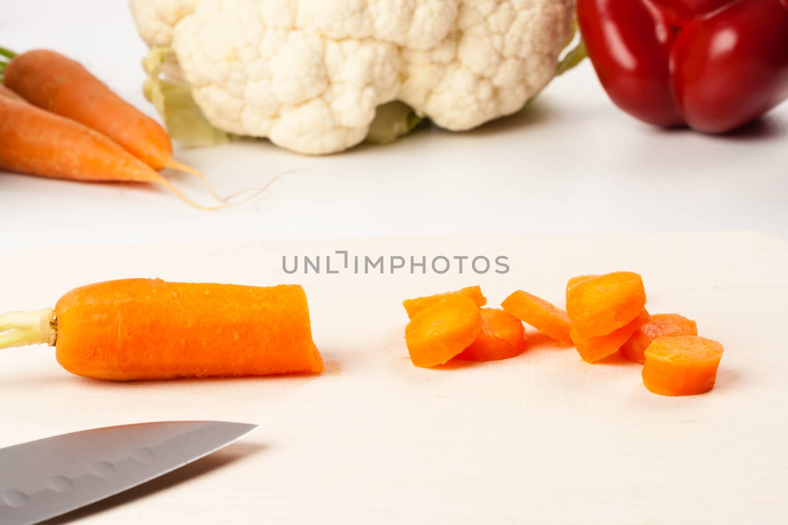 carrot on cutting board with different vegetables in the background