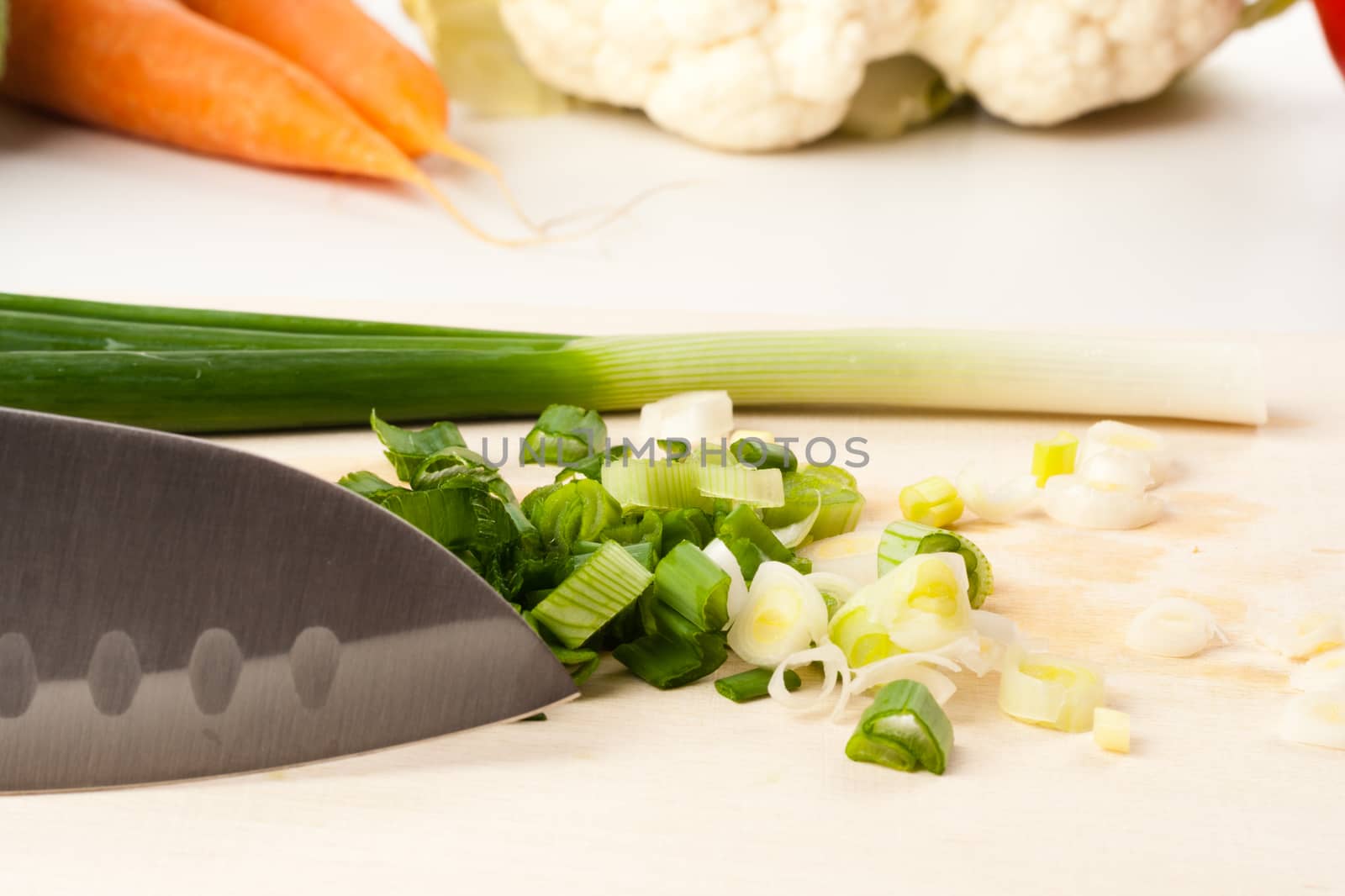 onion on cutting board with different vegetables in the background