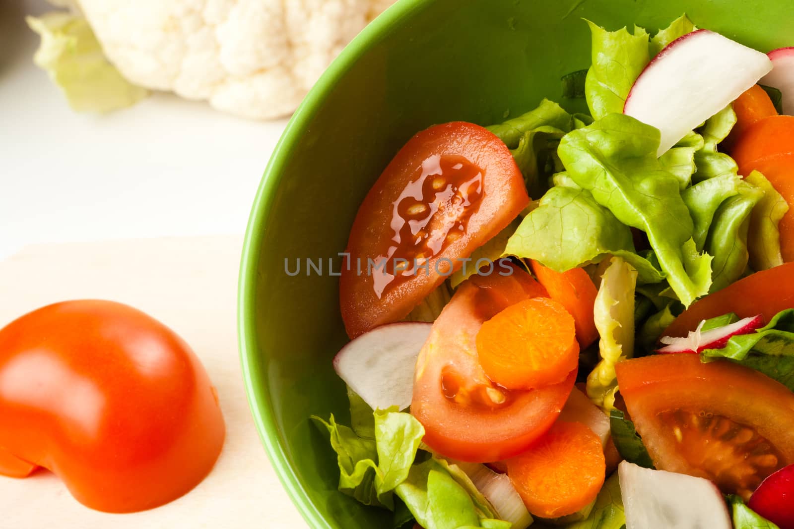 vegetable salad in a green bowl with different vegetables