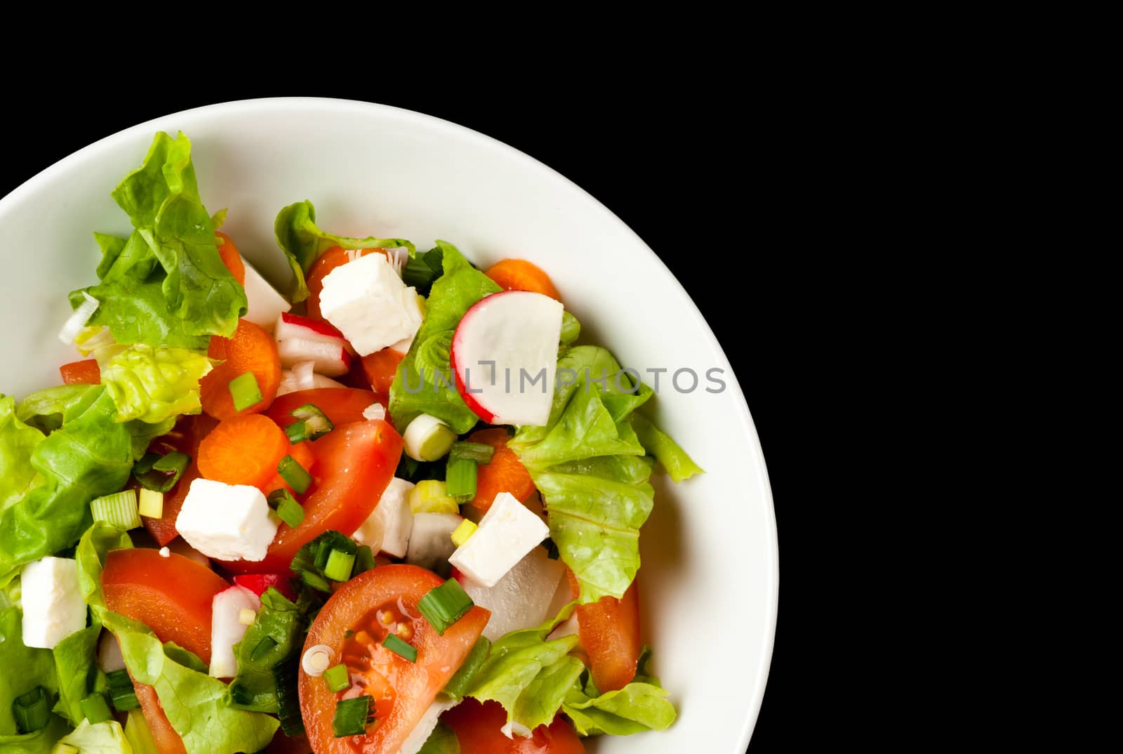 vegetable salad in white bowl on black background