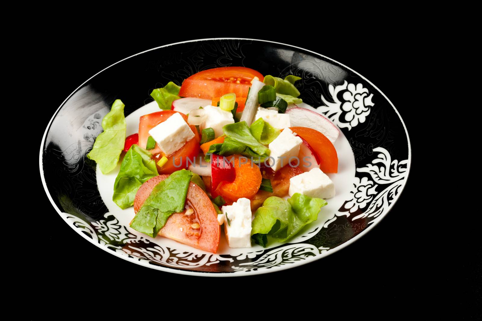 vegetable salad in stylish balck and white plate on black background