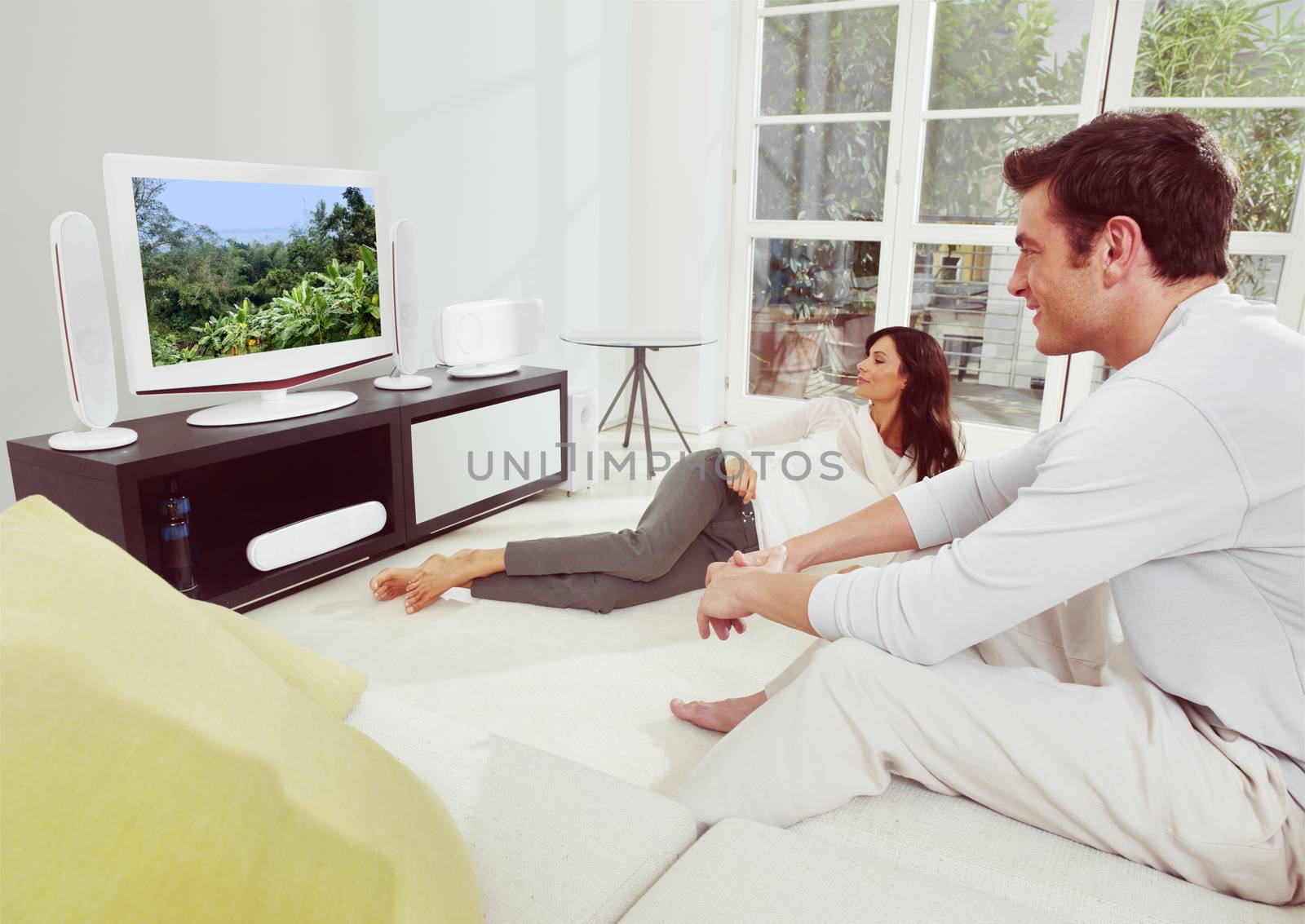 Portrait of young  happiness couple watching tv lying on bed 