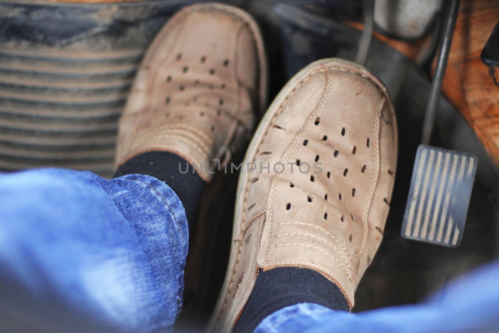 Mans feet pushing on the accelerator of automobile