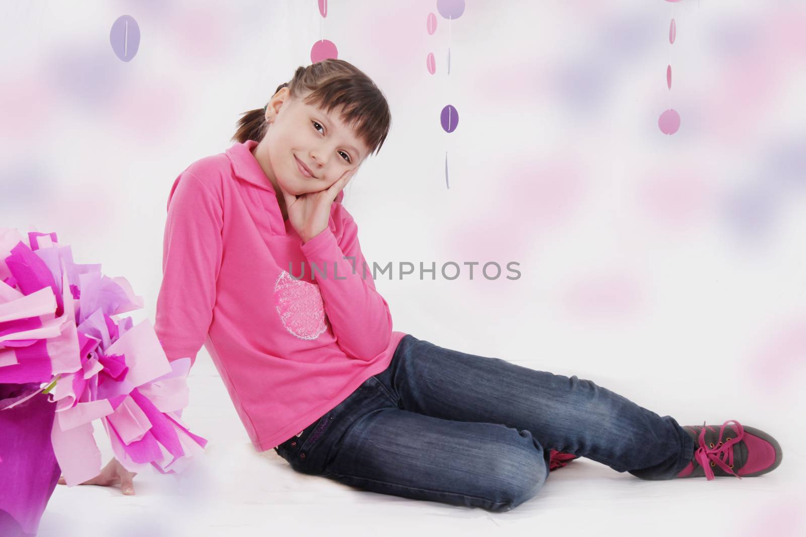 Smiling teenage girl sitting in pink decoration
