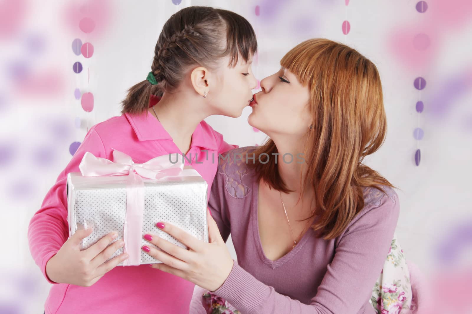 Mother and daughter kissing and holding present by Angel_a