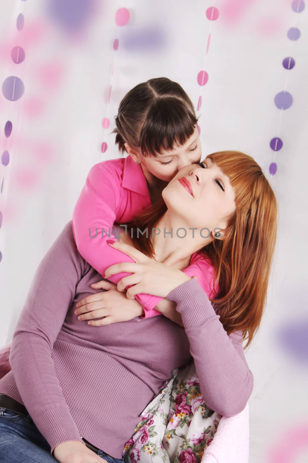 Mother and daughter kissing, pink decoration