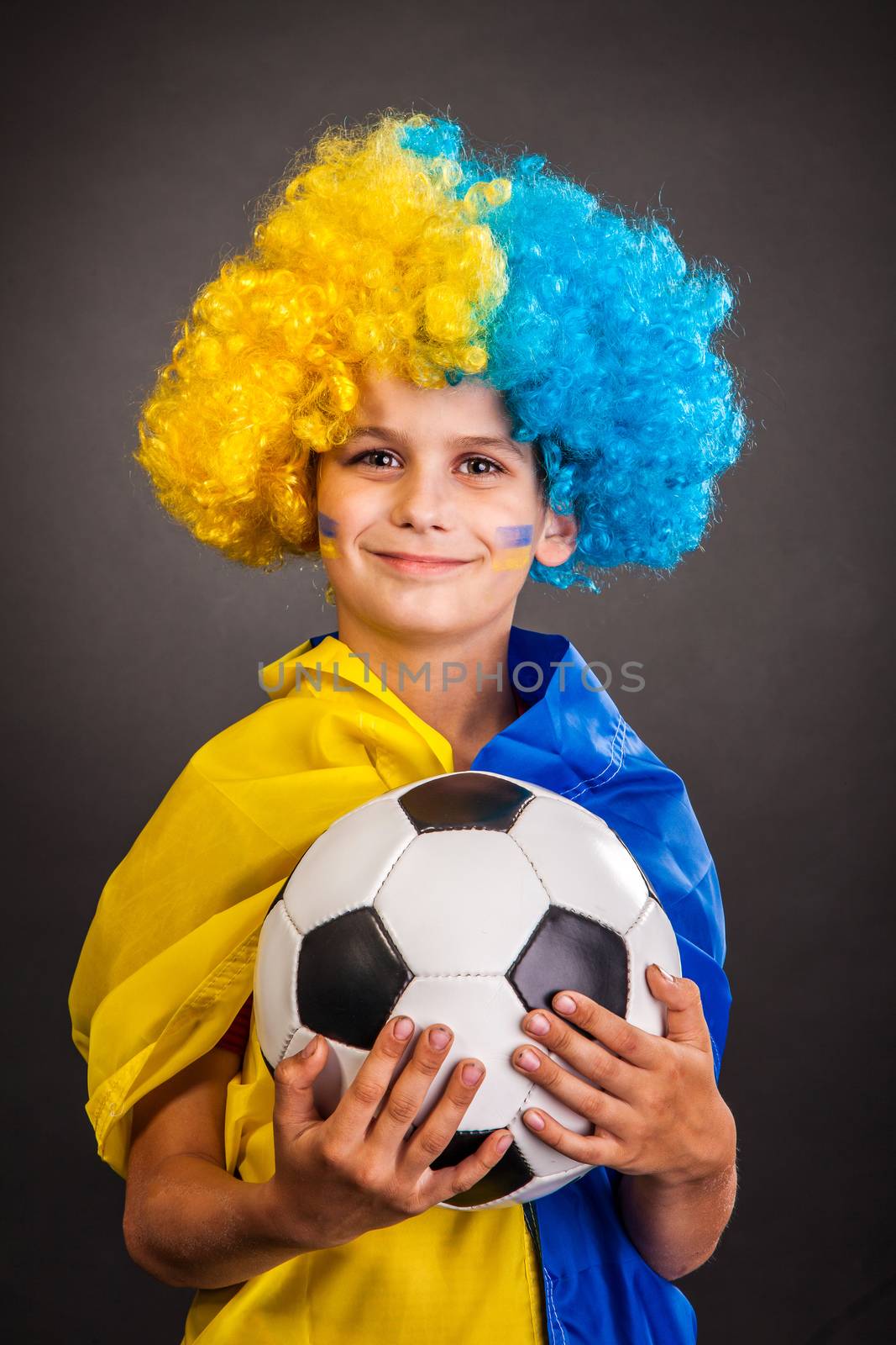 Football fan with a blue and yellow ukrainian flag painted on his face on black background
