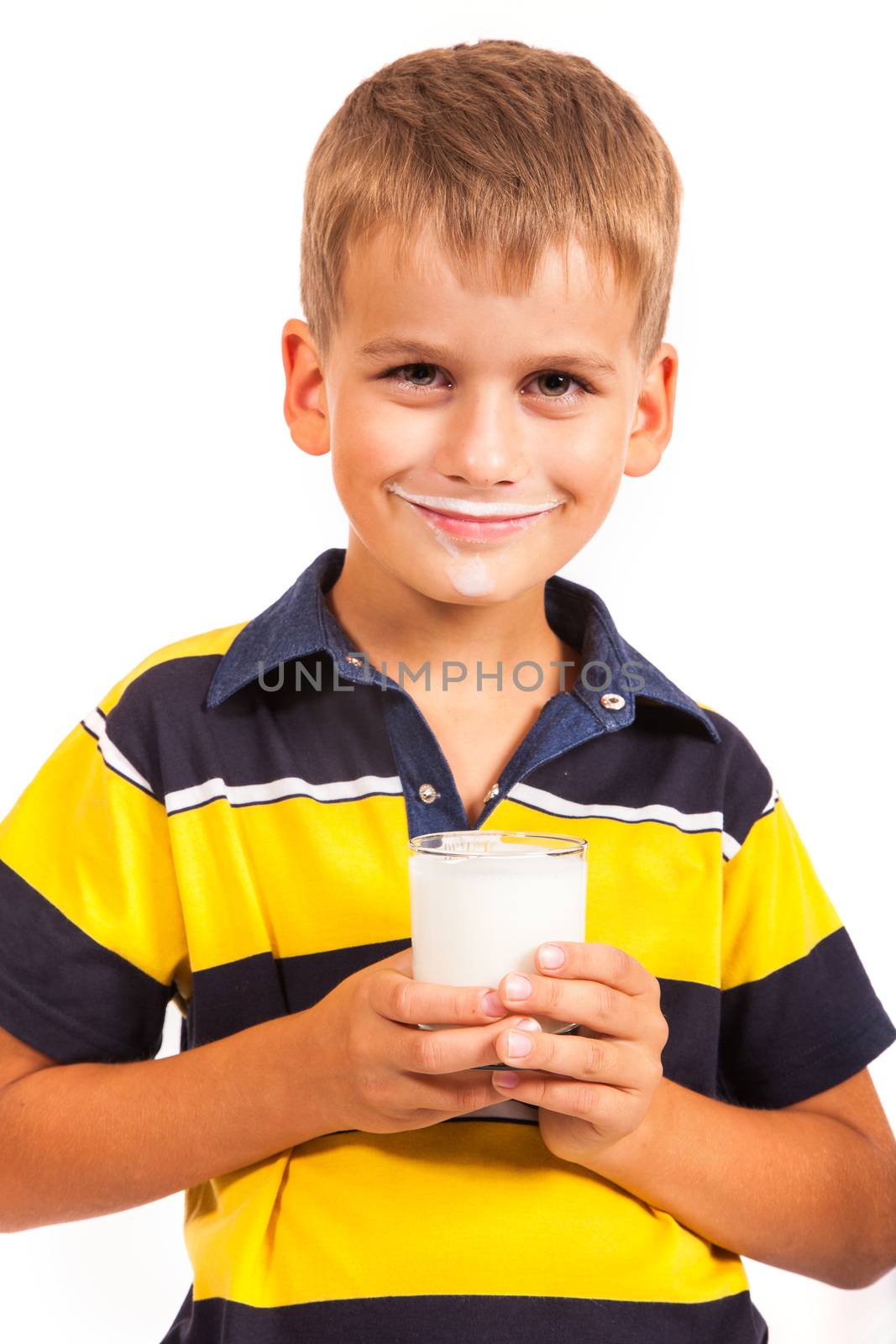 ��ute boy is drinking milk. Schoolboy is holding a cup of milk isolated on a white background