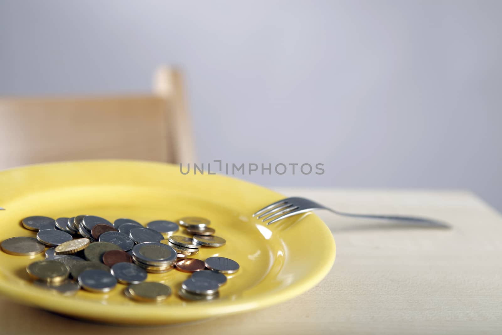 Many Euro coins in a yellow plate.