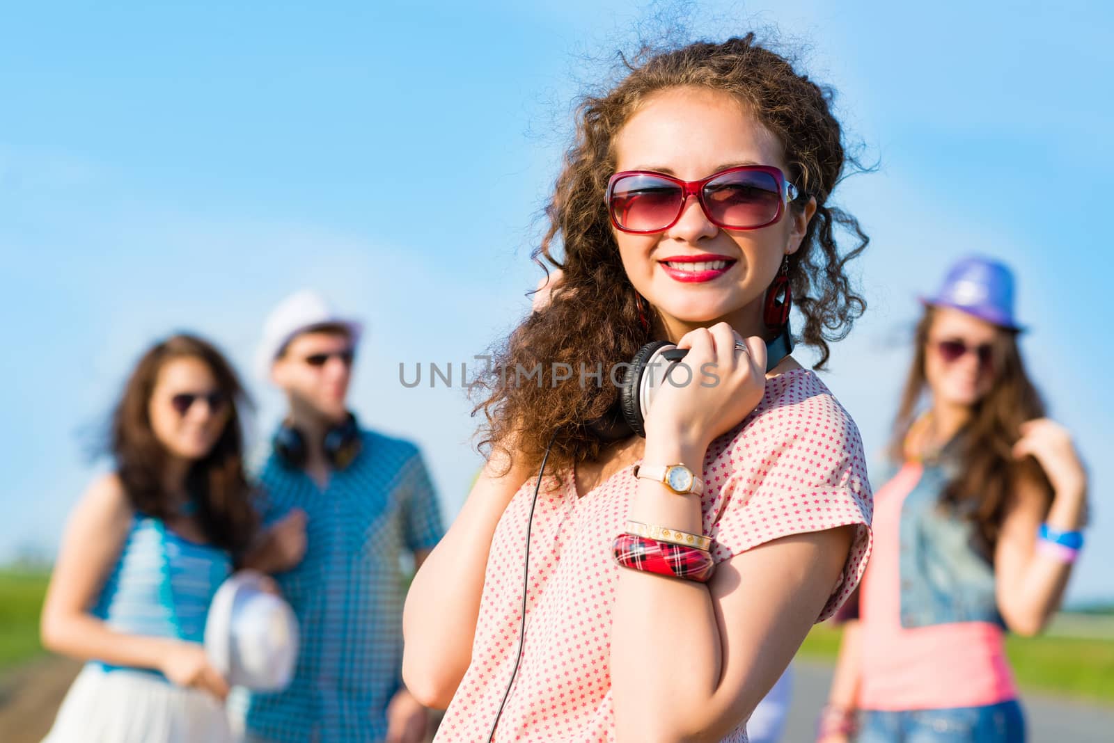 young woman with headphones on a background of blue sky and funny friends