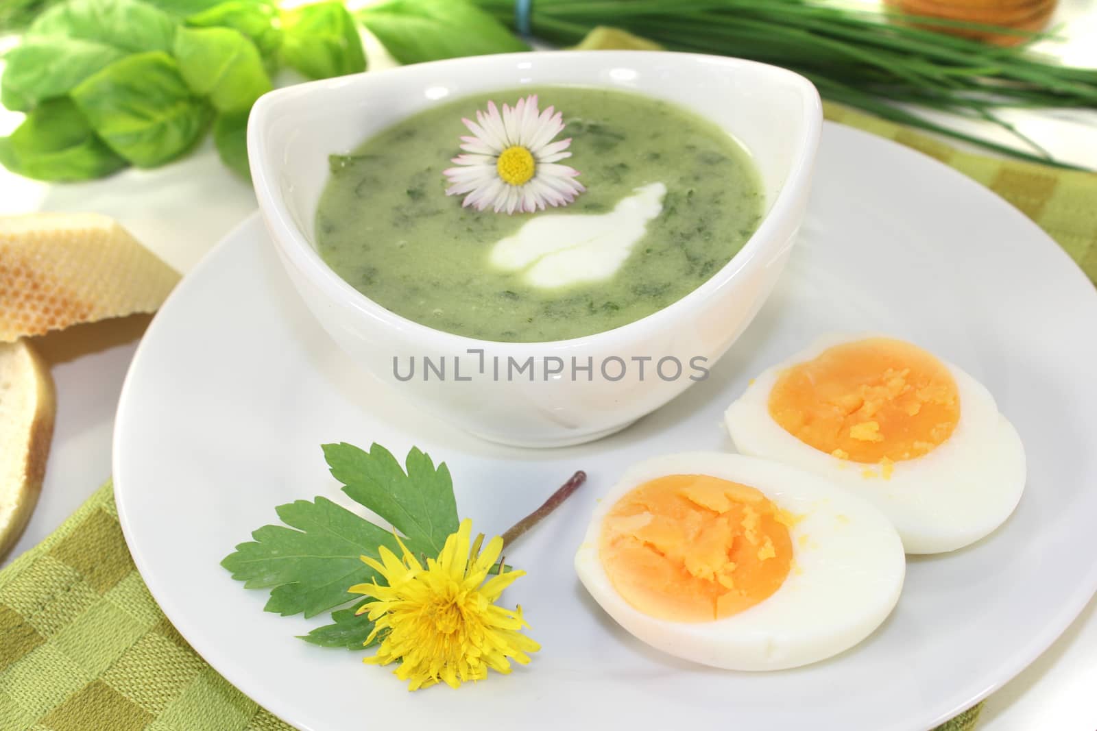 green herbs soup with eggs and a dollop of cream