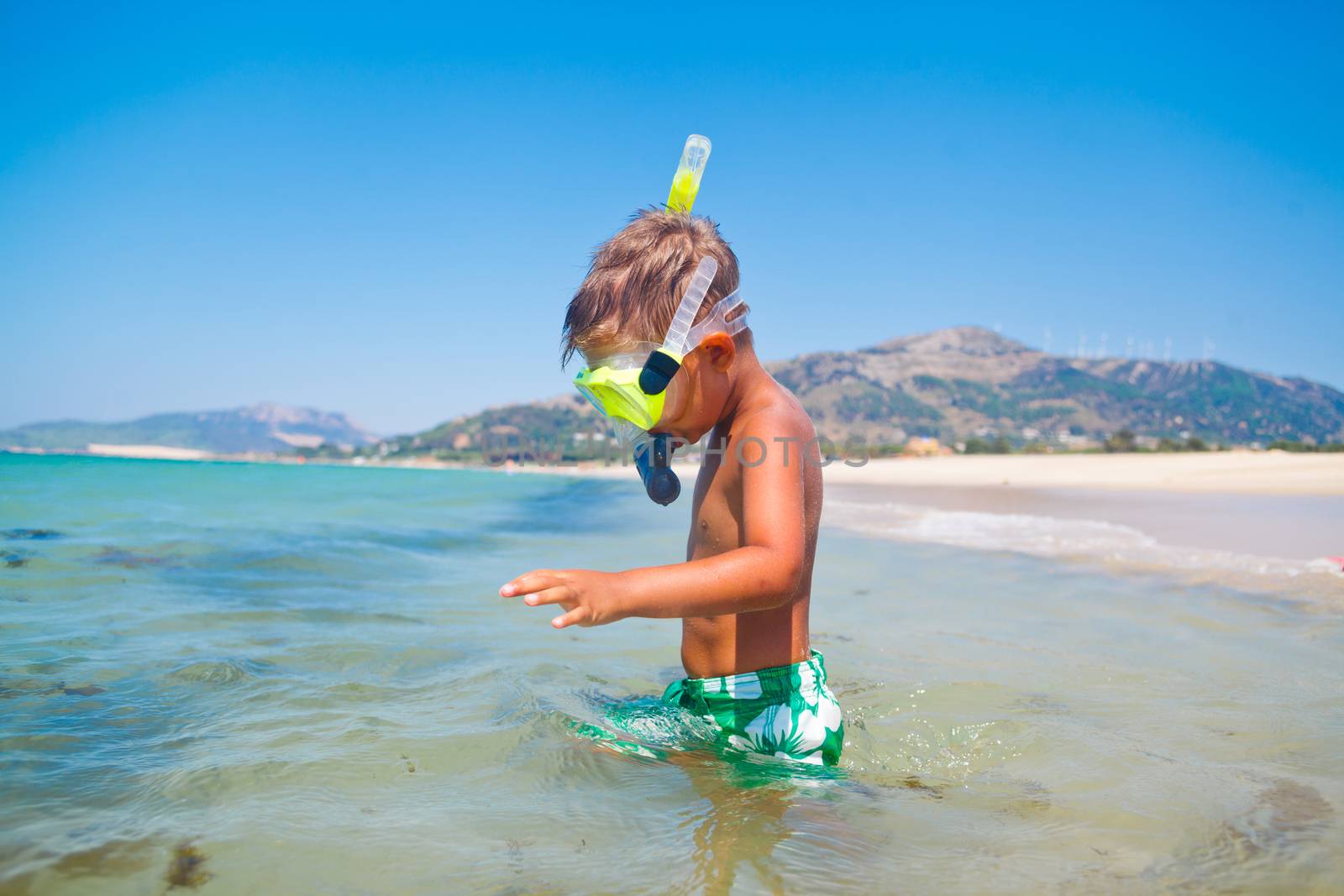 Summer vacation - Portrait of happy boy in face masks and snorkels, sea in background.