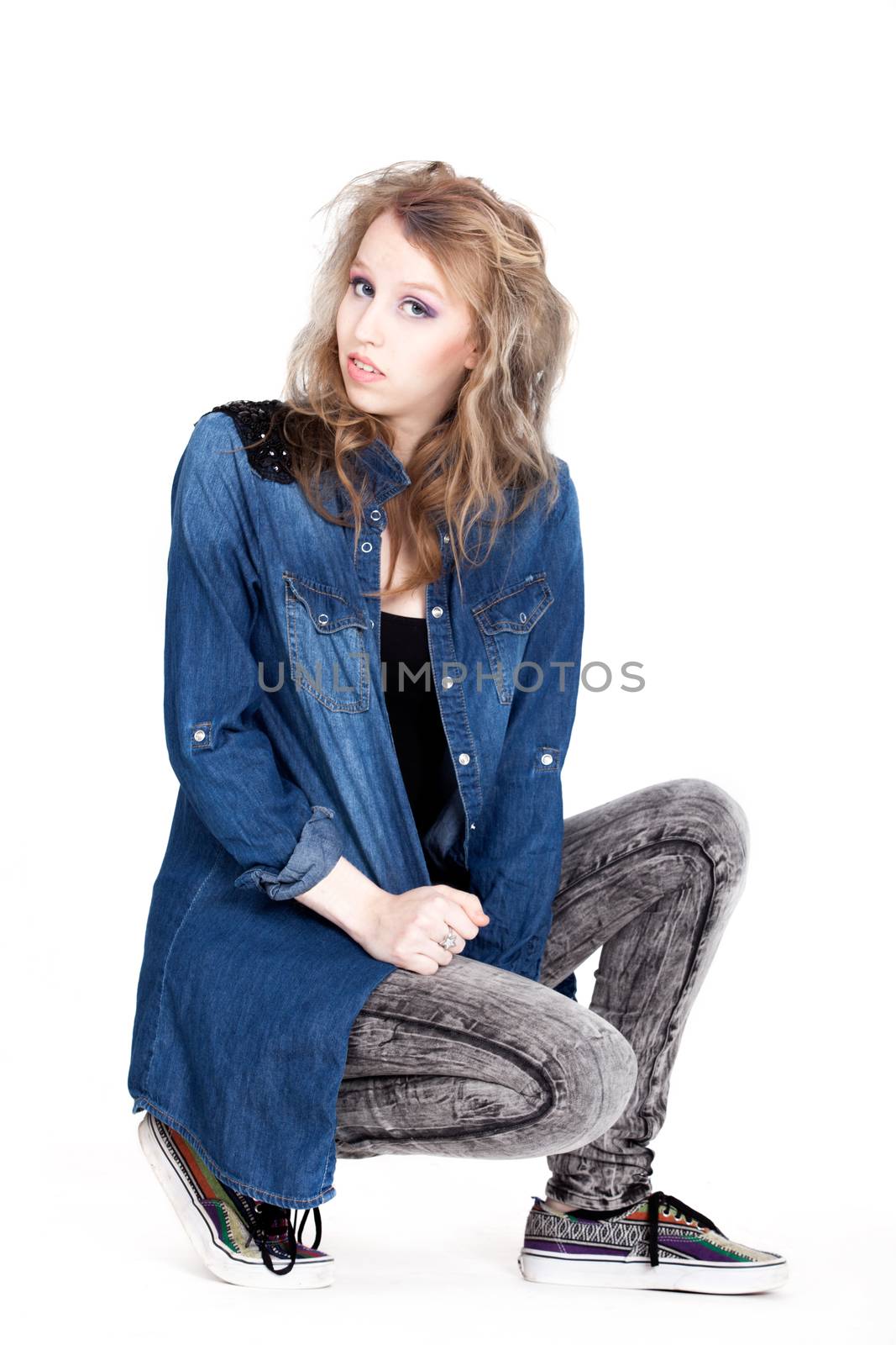 Young tough blond teenage girl with jeans blouse on a white background