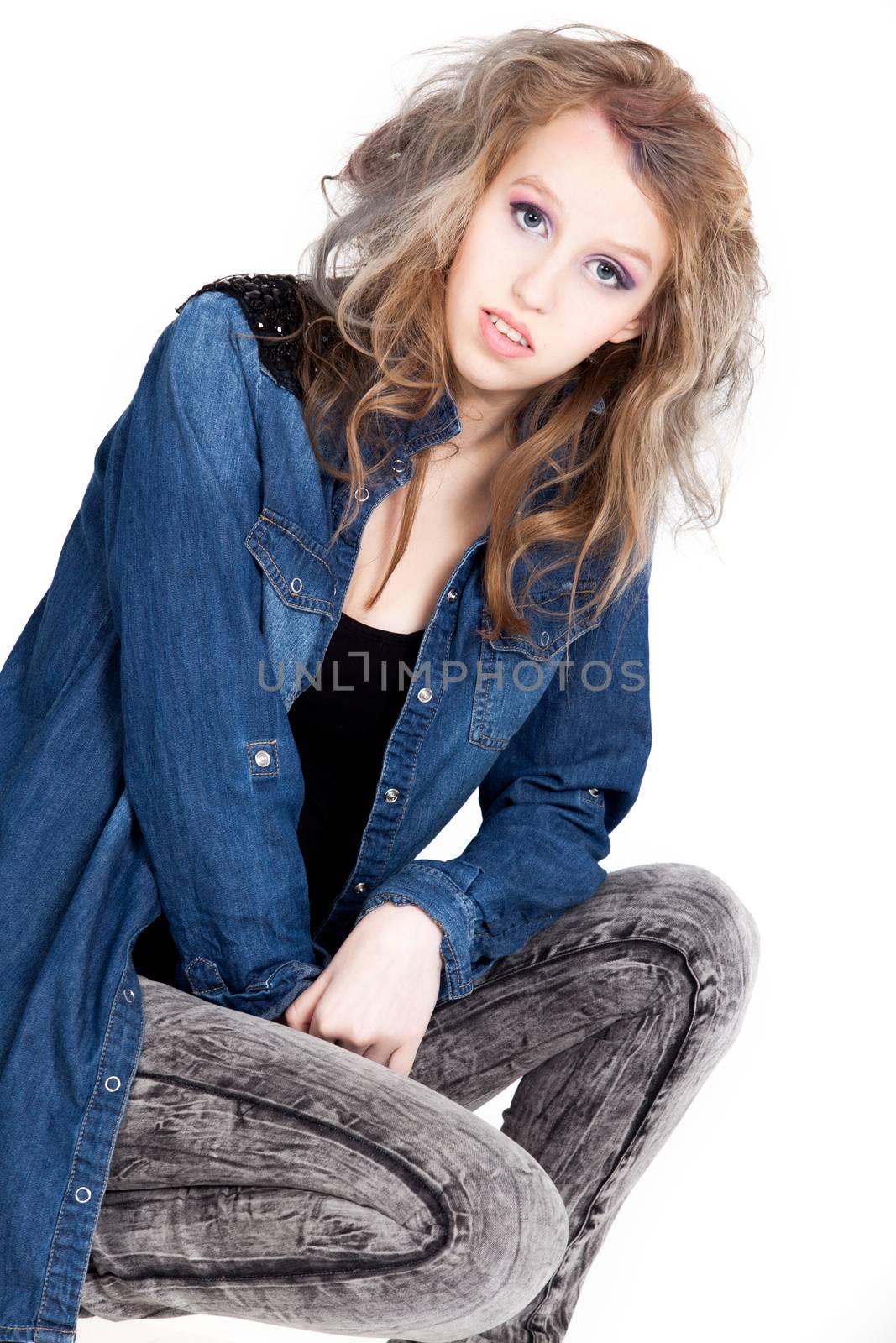 Young tough blond teenage girl with jeans blouse on a white background