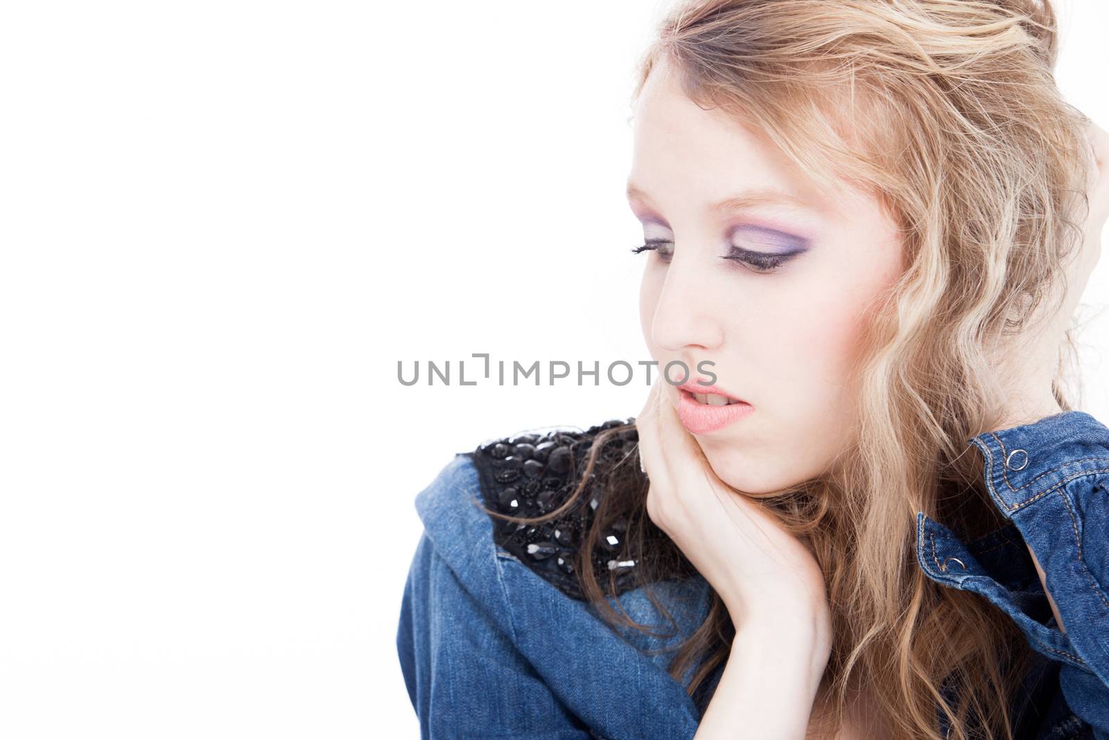 Young tough blond teenage girl with jeans blouse on a white background