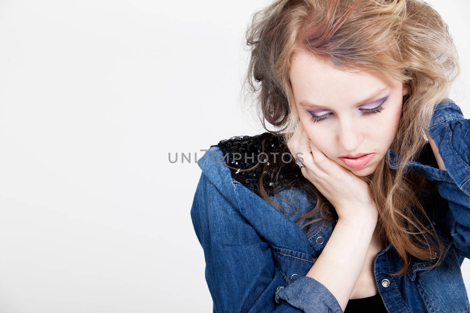 Young tough blond teenage girl with jeans blouse on a white background