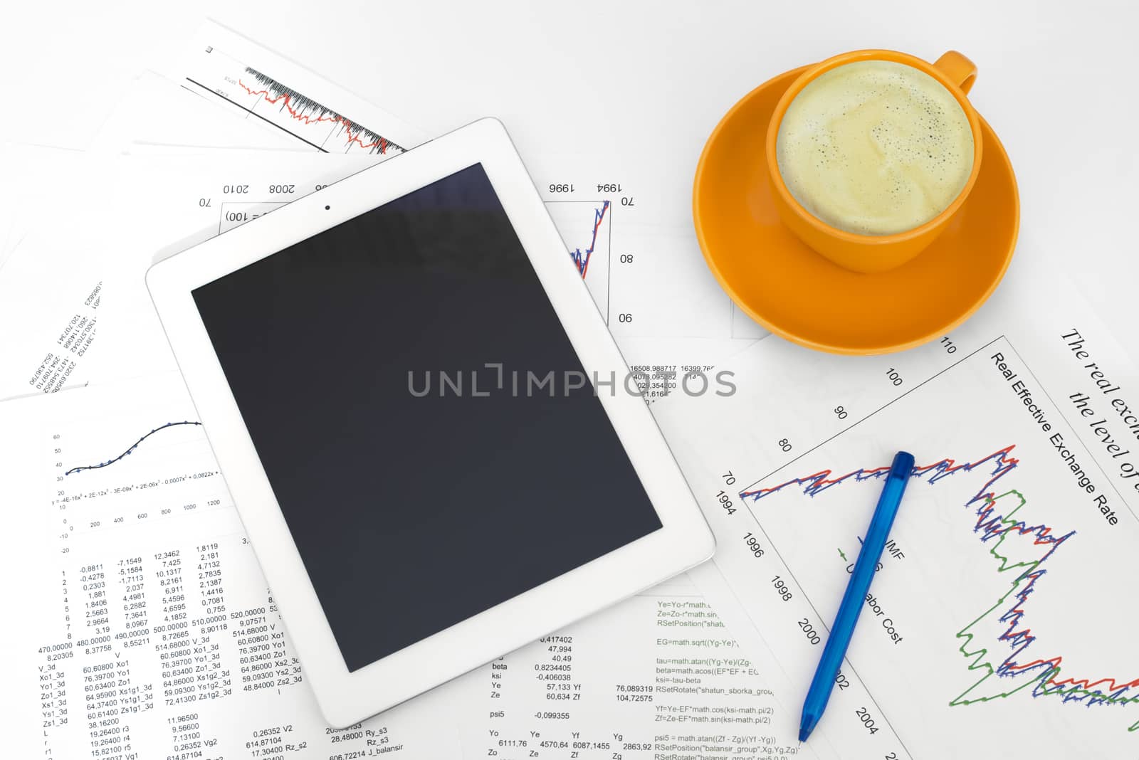 Tablet pc, cup of coffee and paper with graphs. Business concept