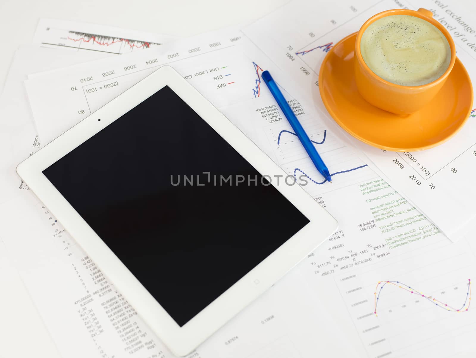 Tablet pc, cup of coffee and paper with graphs. Business concept