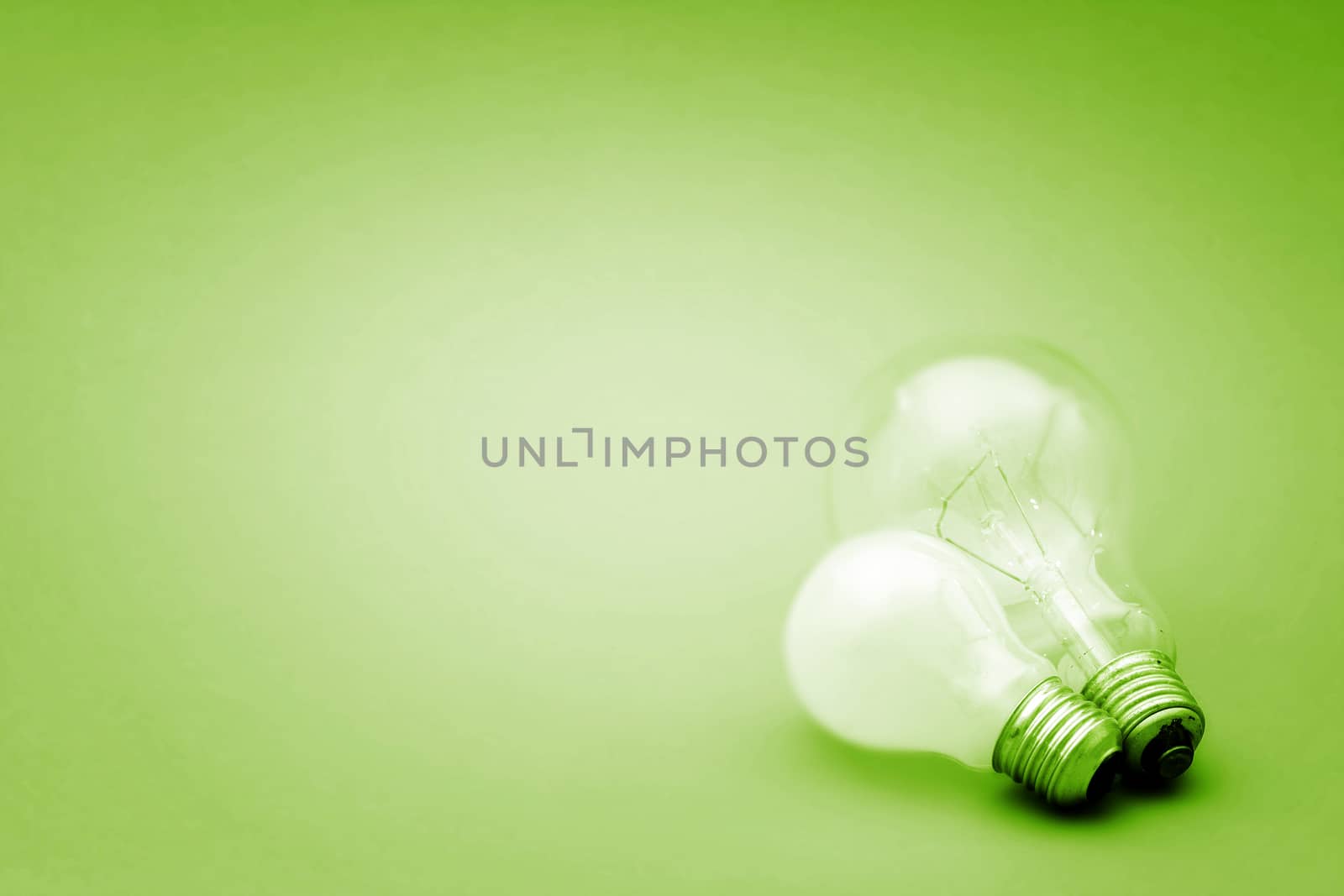 Background with lit lightbulb. Isolated on green
