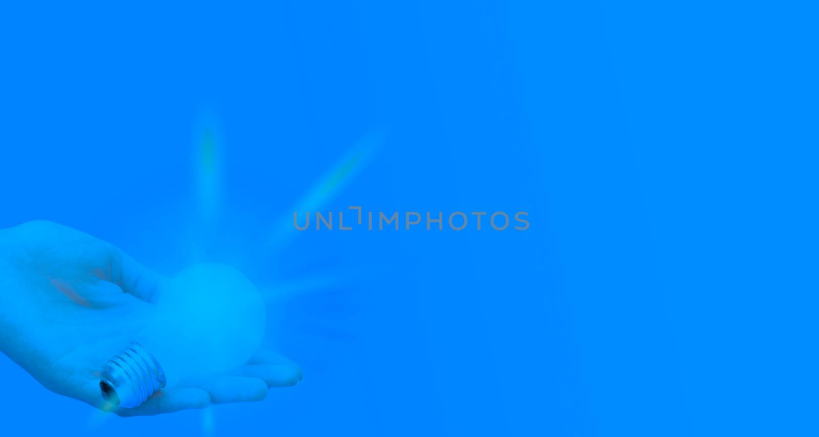 Background with lit lightbulb. Isolated on blue