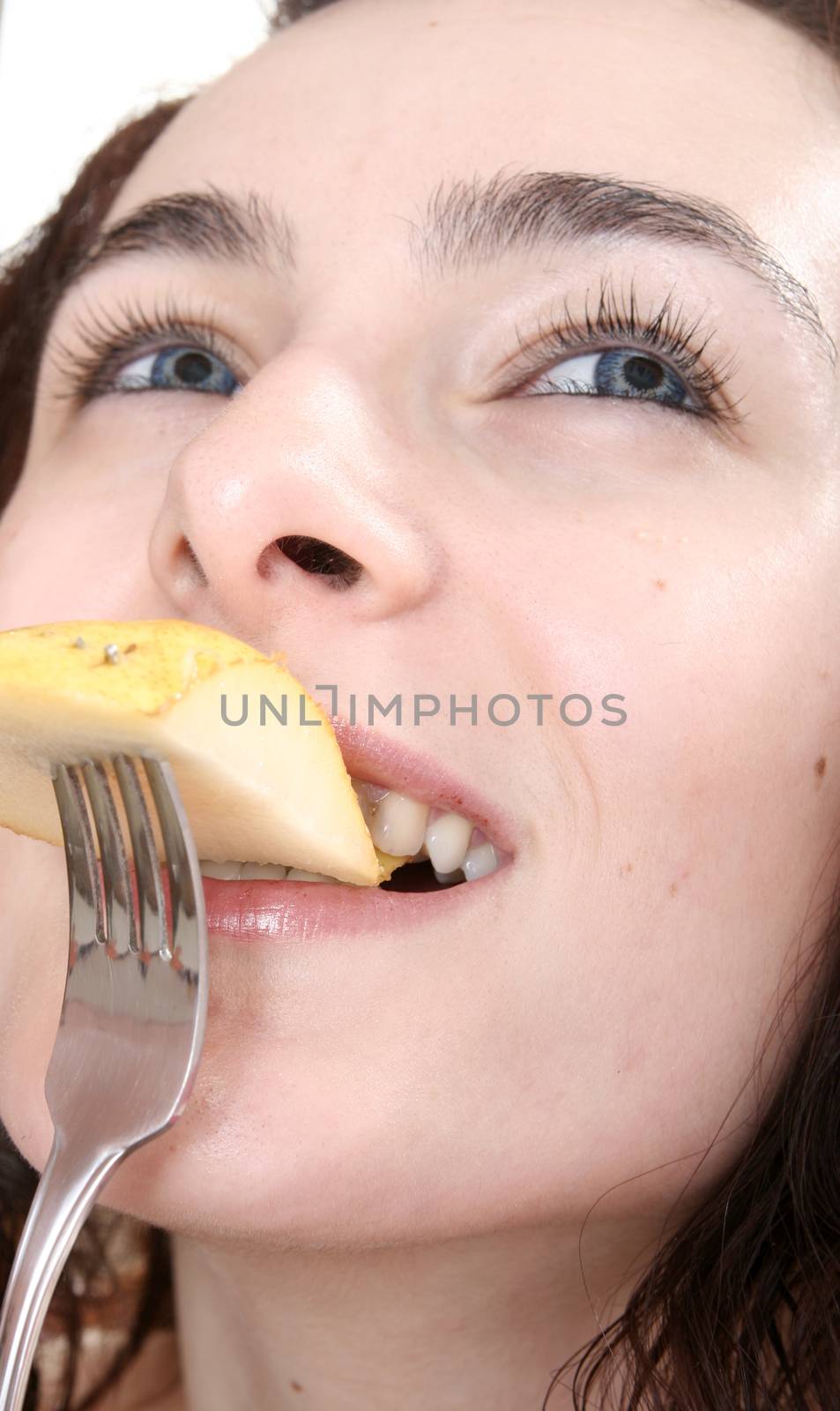 Woman eating tasty pear with forch.