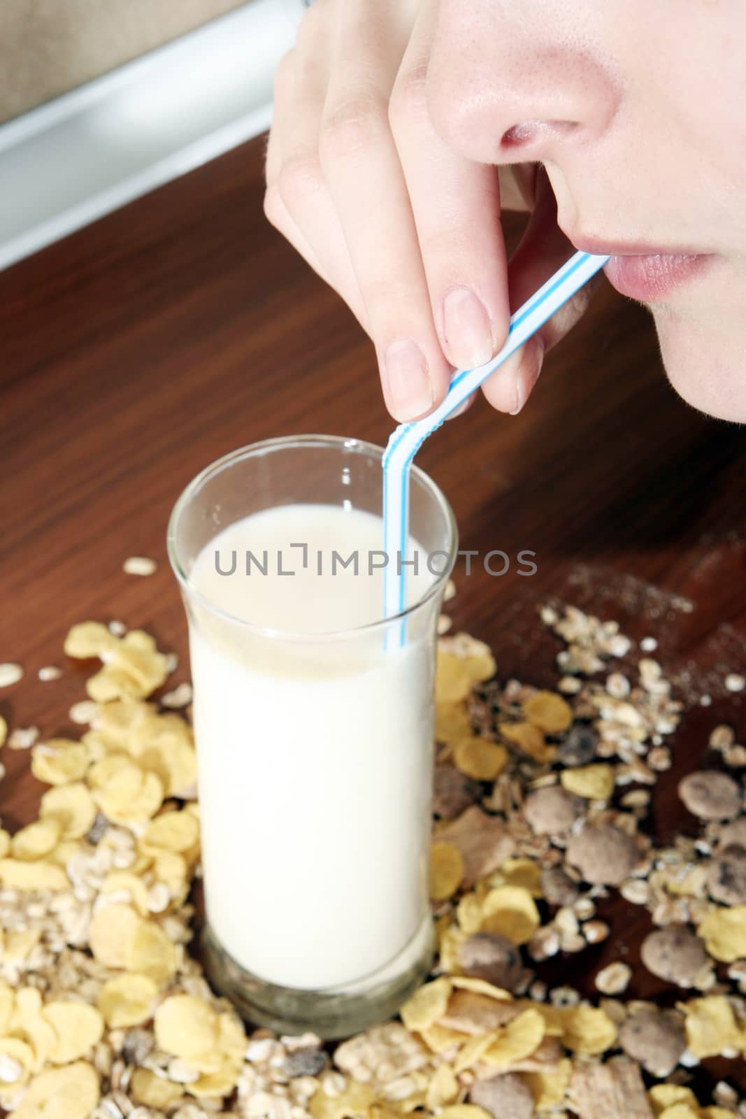 Young people eating milk with cereals by arosoft