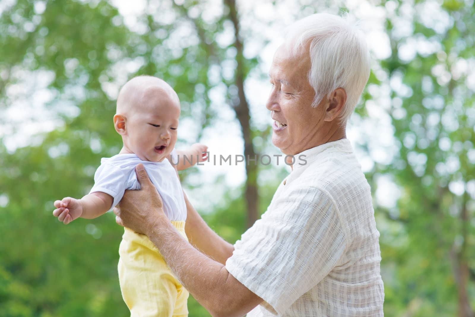 Asian grandfather having fun with his grandson outdoor