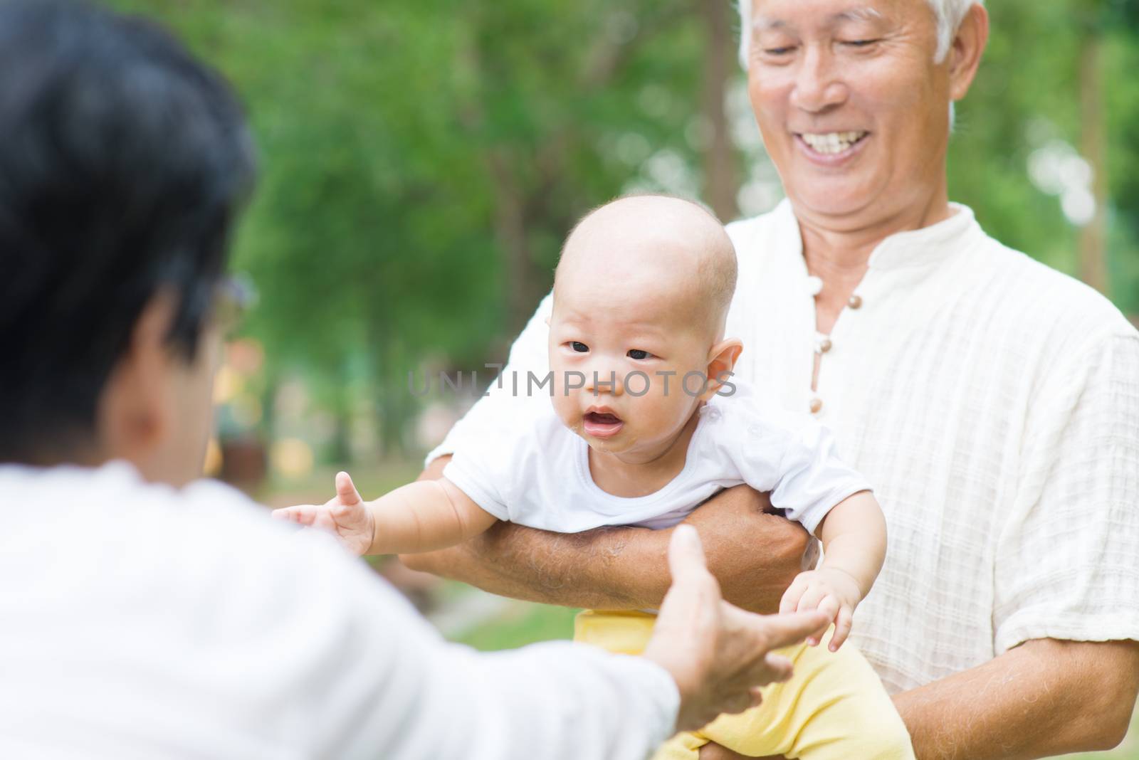 Asian grandparents playing with grandchild by szefei