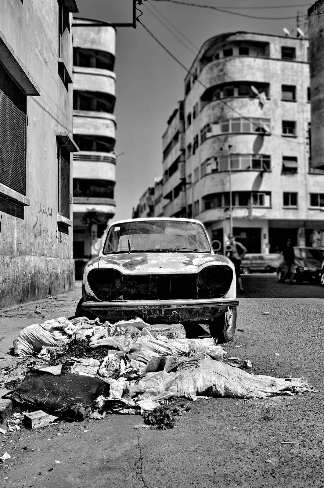 Trash and wrecked car on the street by anderm