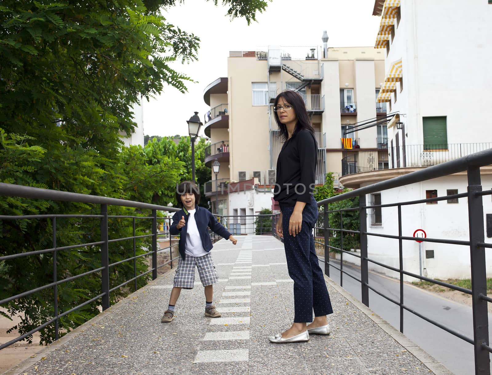 mother and son on the bridge, the boy shows thumbs up