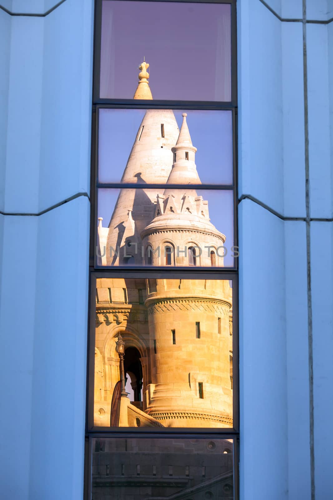 Windows reflection of Fisherman's Bastion lit by sunset, Buda Castle, Budapest, Hungary