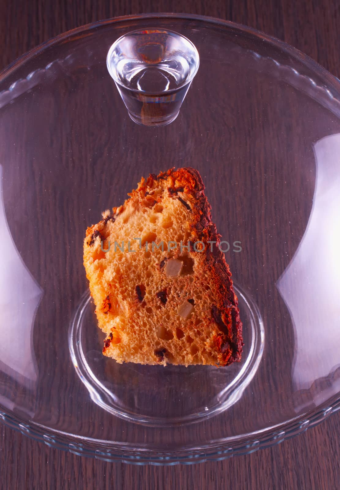 Chocolate cake under glass and over a stand