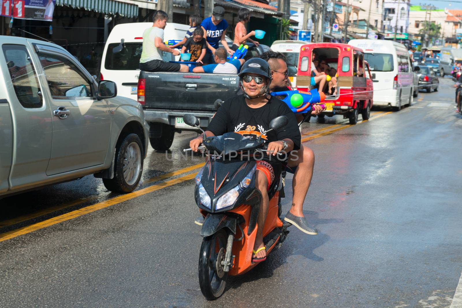 Phuket, Thailand - April 13, 2014: Tourist and residents celebrate Songkran Festival, the Thai New Year by splashing water to each others on Patong streets. 