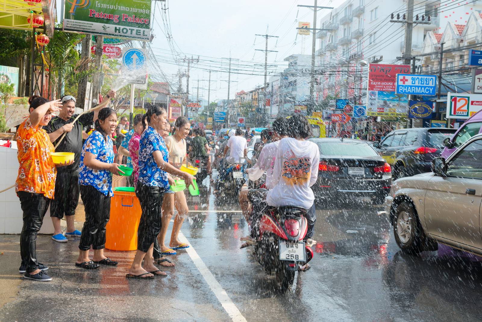 Phuket, Thailand - April 13, 2014: Tourist and residents celebrate Songkran Festival, the Thai New Year by splashing water to each others on Patong streets. 