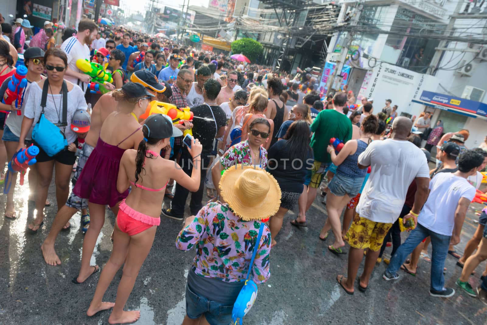 Phuket, Thailand - April 13, 2014: Tourists and residents celebrate Songkran Festival, the Thai New Year by splashing water to each others on Patong streets. 