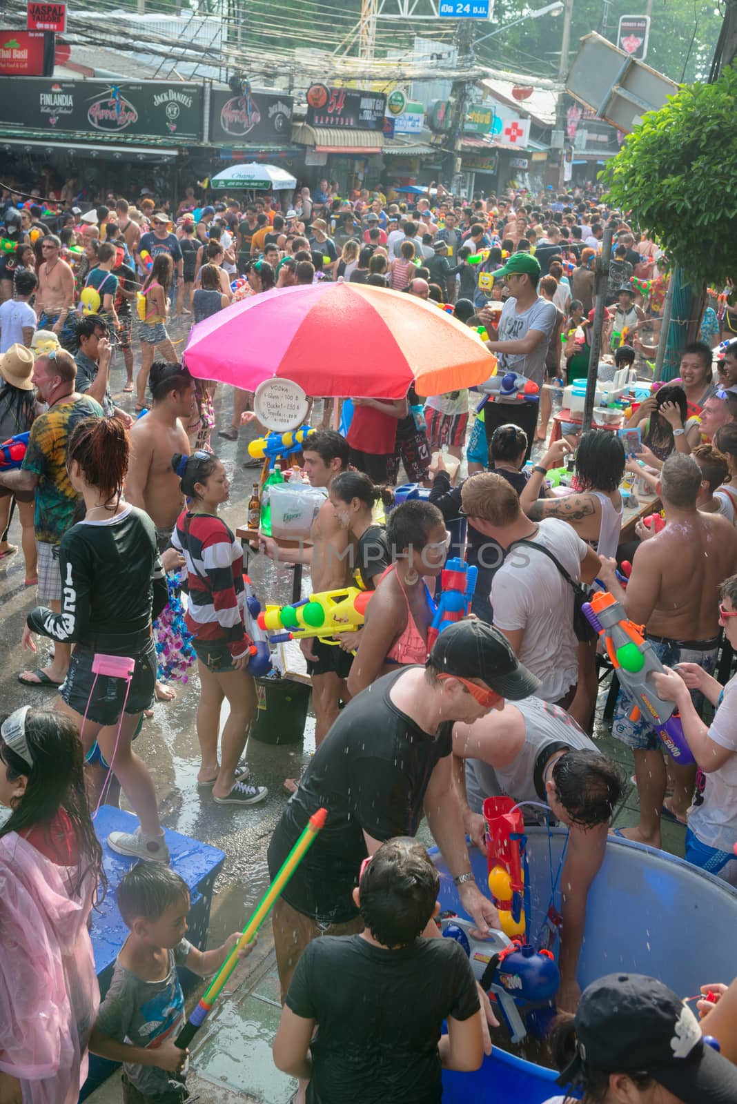 Phuket, Thailand - April 13, 2014: Tourists and residents celebrate Songkran Festival, the Thai New Year by splashing water to each others on Patong streets. 