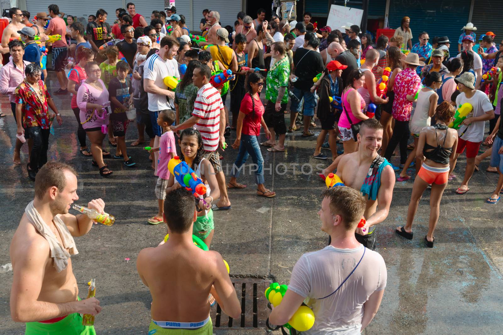 Phuket, Thailand - April 13, 2014: Tourists and residents celebrate Songkran Festival, the Thai New Year by splashing water to each others on Patong Bangla road. 
