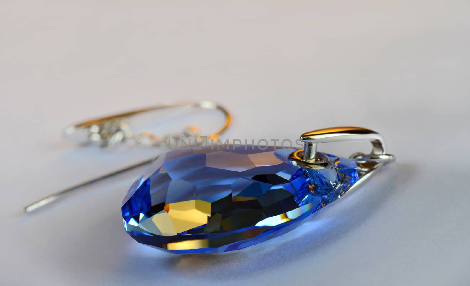 Huge blue crystal earring. Macro photo.