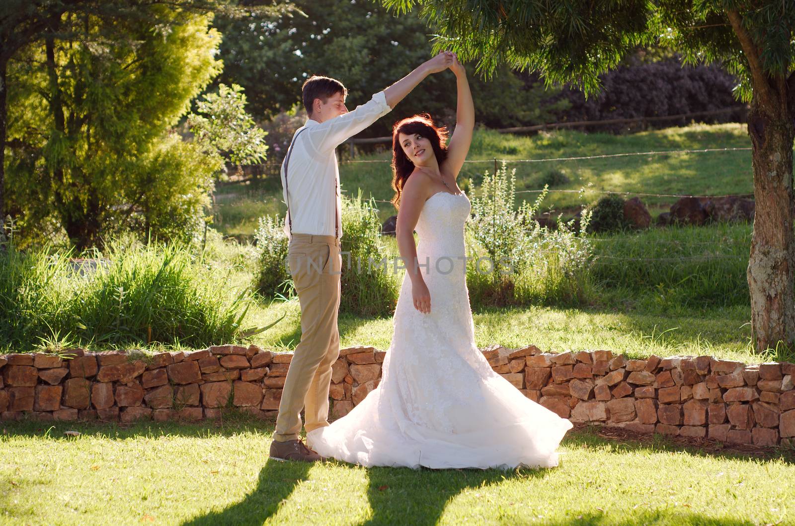 Bride and groom dancing outside garden wedding ceremony