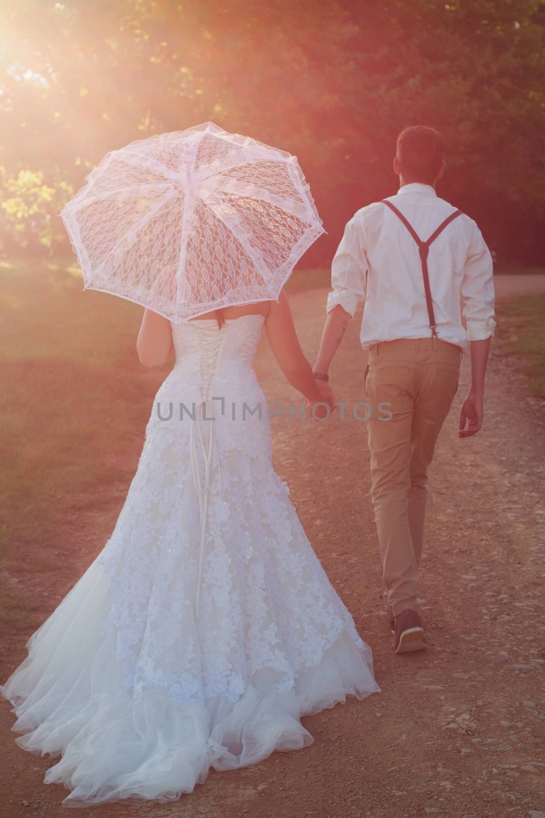 Bride and groom walking off into sunset after wedding ceremony