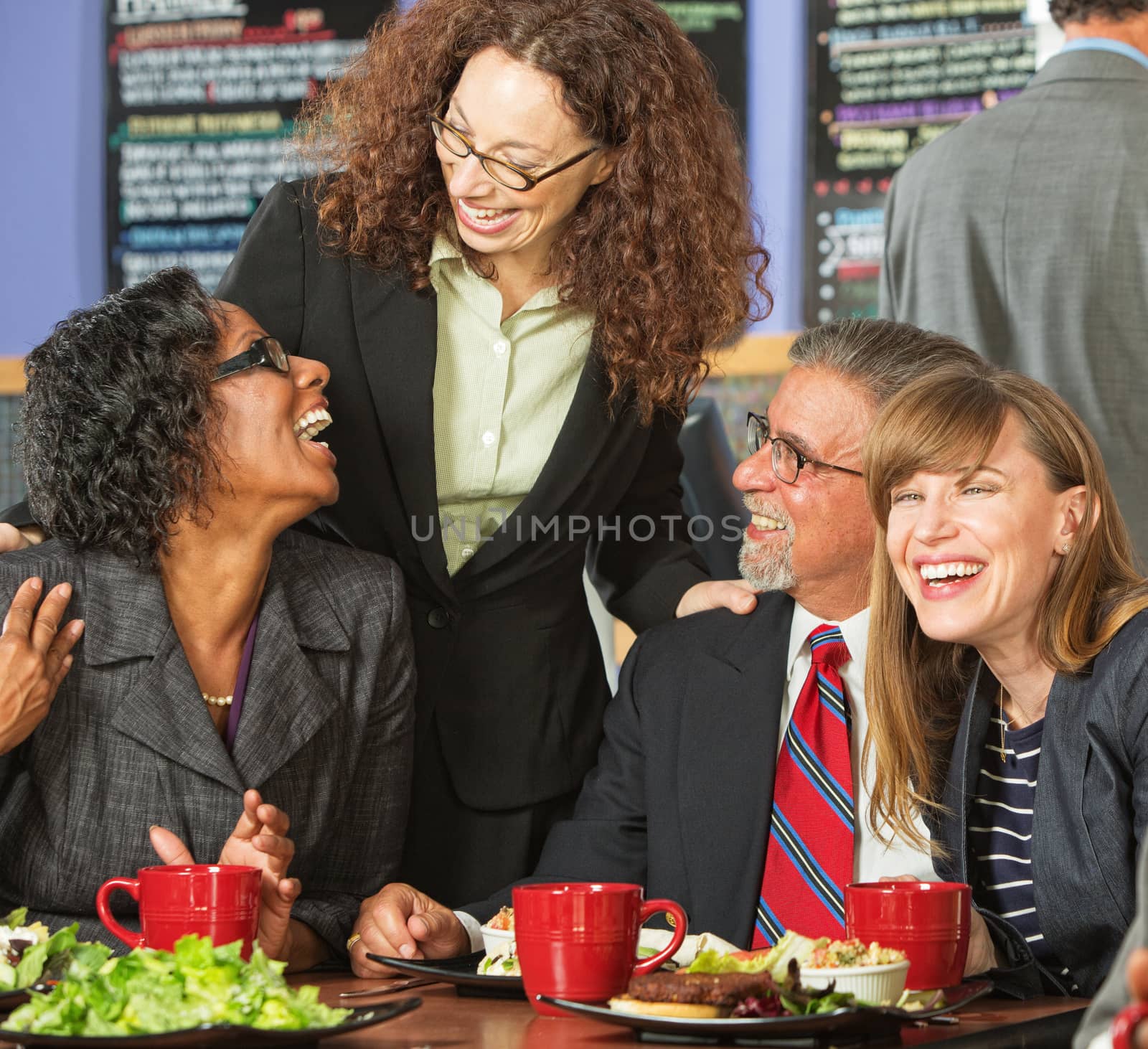 Diverse group of four happy executives having lunch