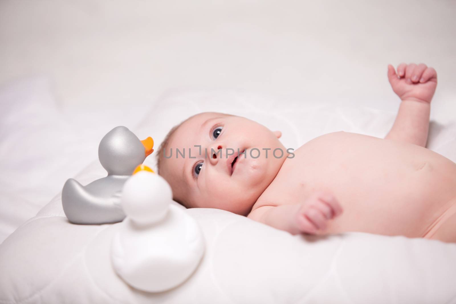 Little baby boy is having a relaxing time on his white blanket