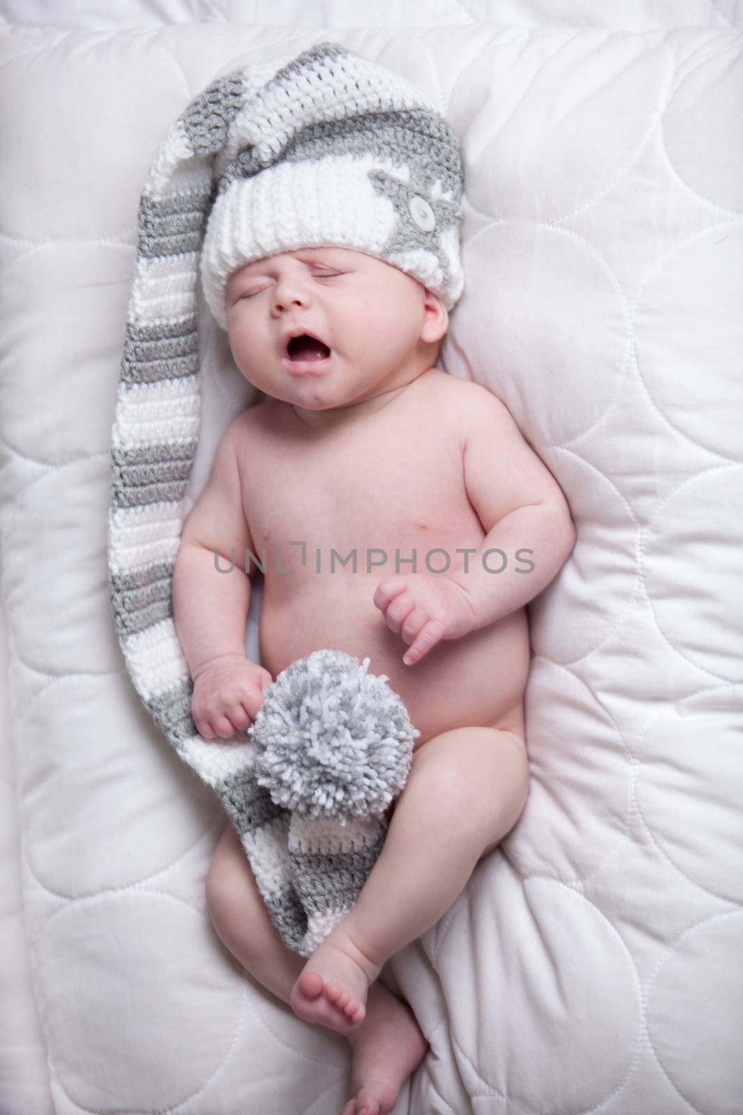 Little baby boy is having a relaxing time on his white blanket