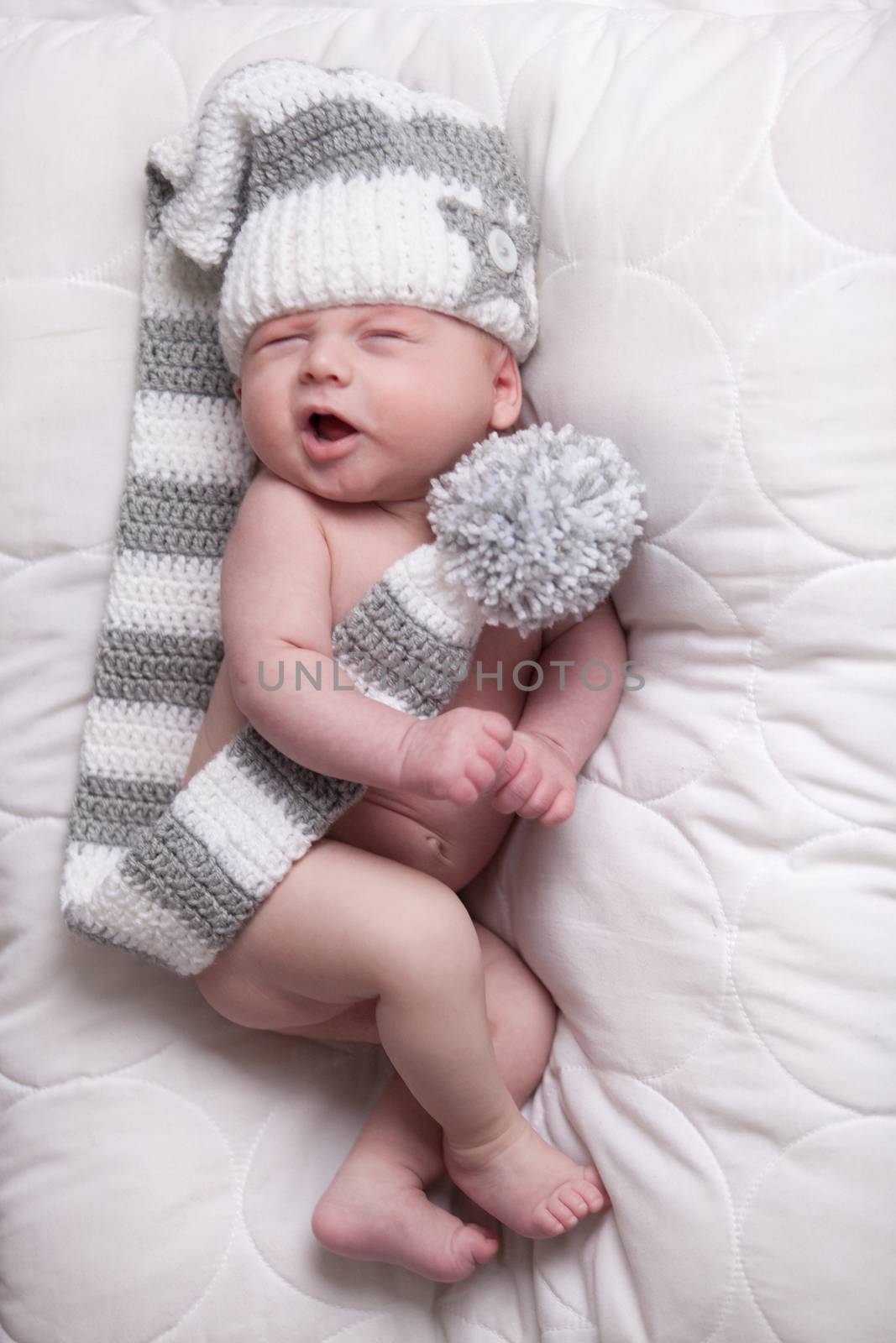 Little baby boy is having a relaxing time on his white blanket