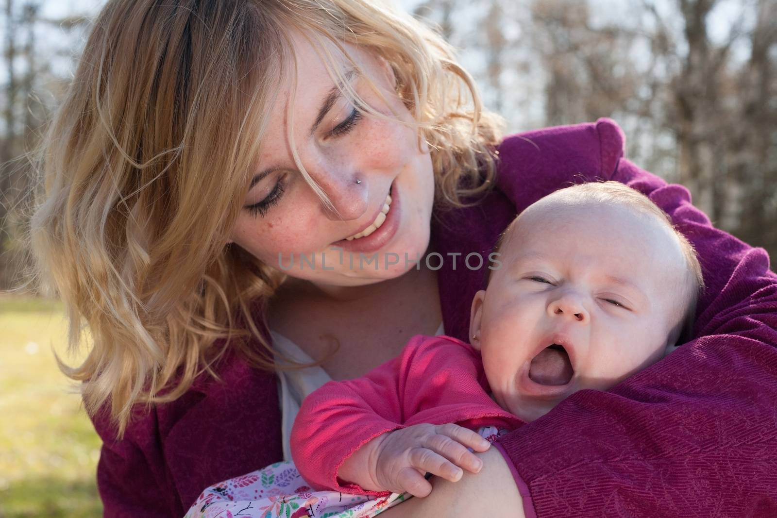 Baby is yawning in mothers arms by DNFStyle