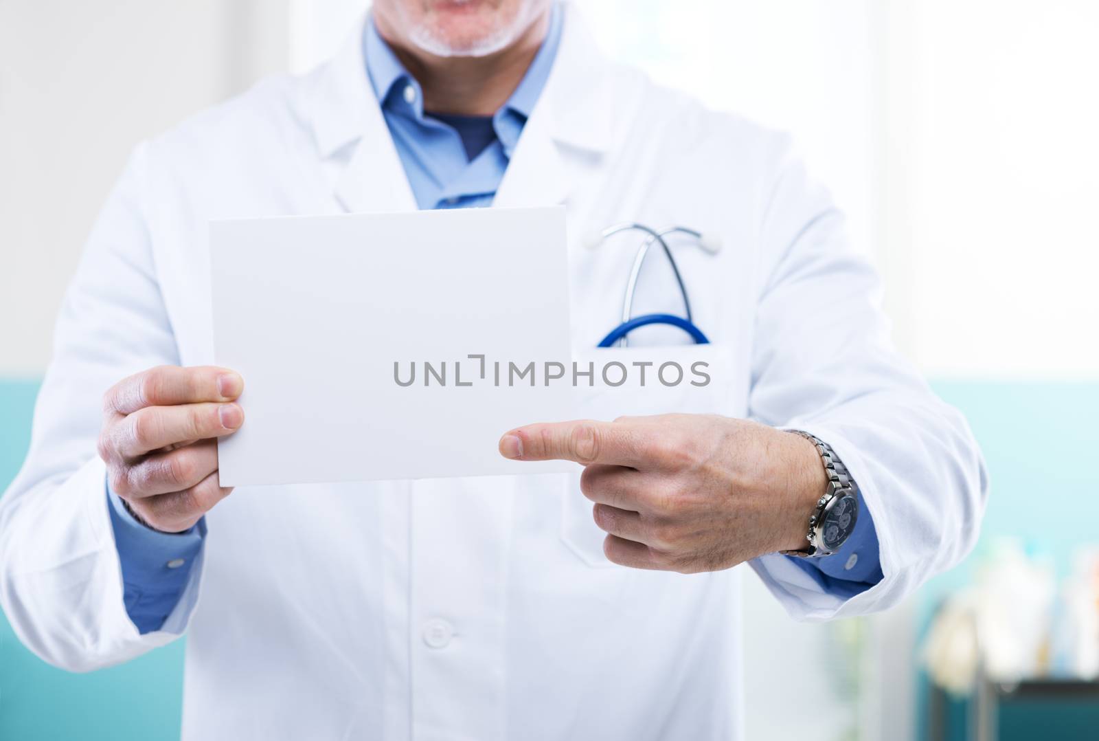 Doctor pointing at a small white sign, a message can be added.