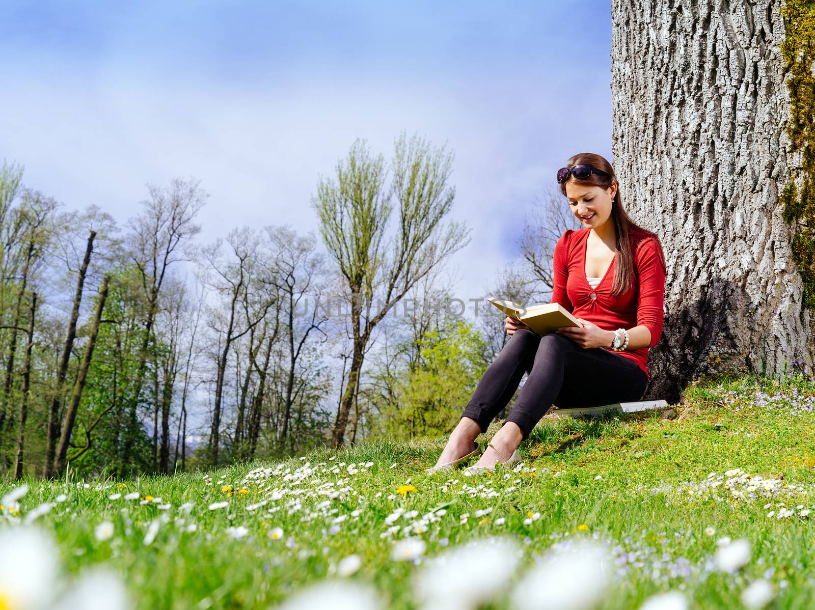 Young woman reading outdoors by sumners