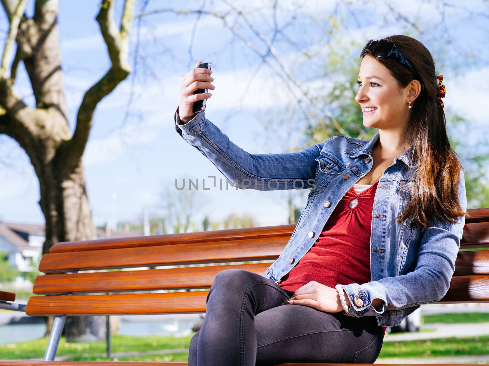 Photo of a beautiful young woman using a smartphone to take a selfie.